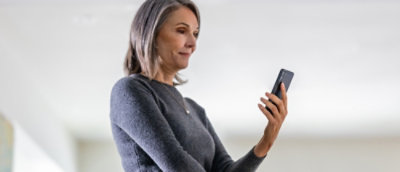 A close-up of a woman's arm holding a phone.