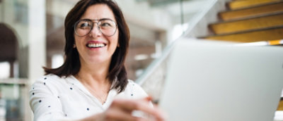 A women wearing spects and smiling.