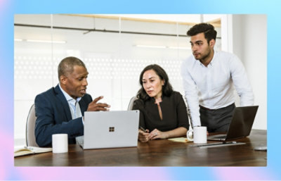 Three people discussing with a laptop open