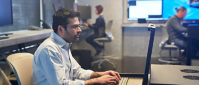 A person sitting at a desk using a laptop.