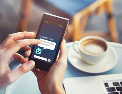 A person holding a cell phone displaying CHATBOT 15:18.