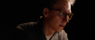 man sitting and observing a computer screen in bright light