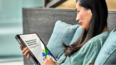 A person sitting on a couch holding a tablet.