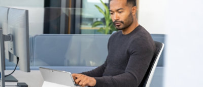 A man sitting in a chair using a laptop.