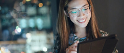 A woman smiling at a laptop