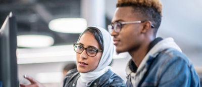 A man and a women discussing something using a desktop