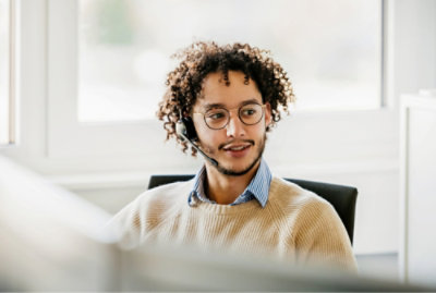 Un homme aux cheveux bouclés portant un casque.
