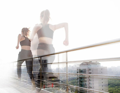 A blurry image of a woman running on a bridge.