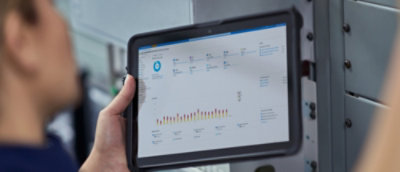 Tablet displaying data charts being used in an industrial setting.