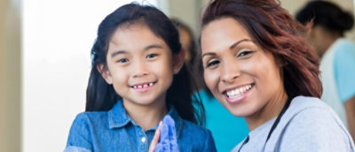 A woman and a girl looking at the camera and smiling