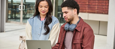 A man and women looking at the laptop screen and discussing