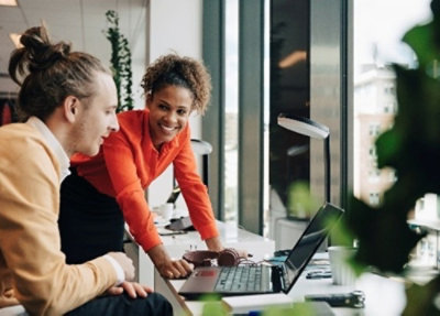 A man and woman looking at a laptop.
