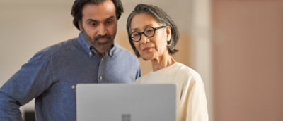 A man and woman looking at a computer screen.