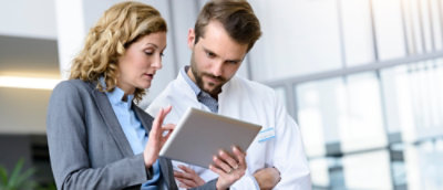 A man and woman looking at a tablet.