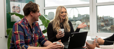 Two people chatting with a laptop on the table