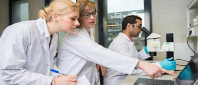Three people conducting laboratory analysis.