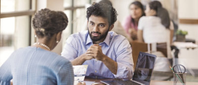 Two people facing each other conversing.