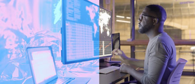 A man sitting at a desk looking at a computer screen.
