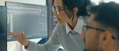 A person pointing at a computer screen.
