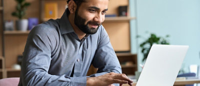 A person sitting at a desk using a laptop.