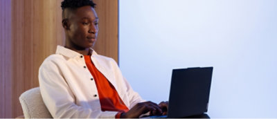 Une personne en veste blanche utilisant un ordinateur portable.