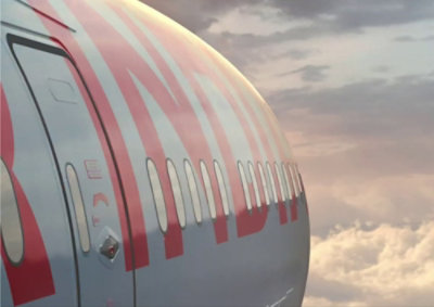 A close-up of a plane with white clouds in the sky.