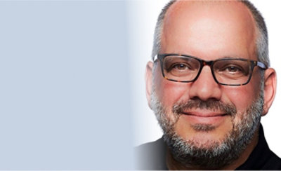 A close-up of a person's face wearing glasses.