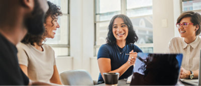 Un gruppo di persone sorridenti sedute intorno a un tavolo