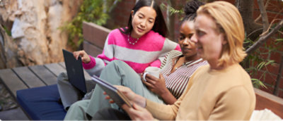 Un gruppo di persone sedute a una panchina che guardano un computer