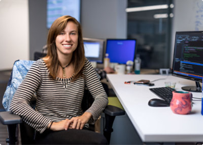 Una persona seduta a una scrivania con un computer.
