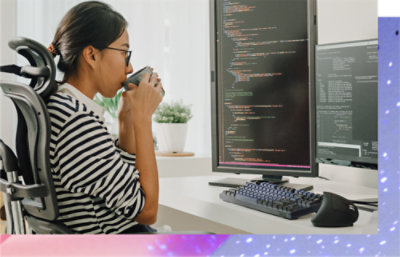 Una persona che beve un caffè e guarda lo schermo di un computer