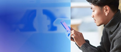 A close-up of a person's hand holding a device with a blue and white background.
