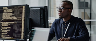 A man sitting at a desk with a computer screen visible.