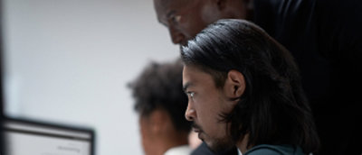 A close-up of a man's face with long hair and a beard.