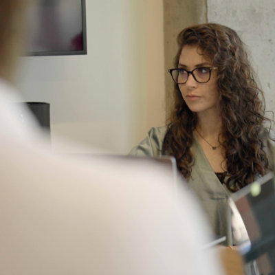 A man explaining something to a women by showing laptop screen.