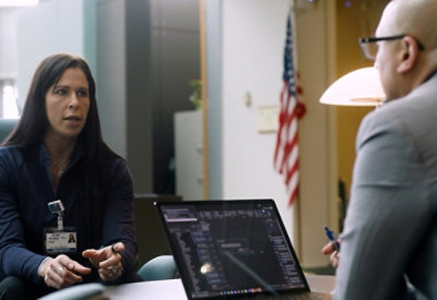 A woman with long hair sitting at a desk.