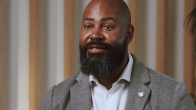 A man wearing a white shirt and a grey jacket.