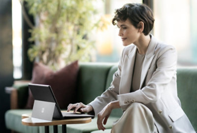 A person sitting on a couch using a laptop.