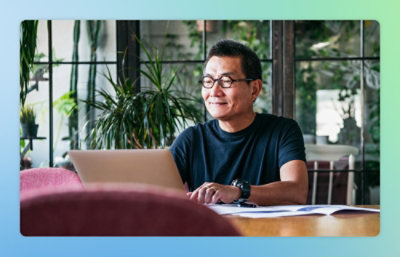 A person sitting at a table using a laptop.