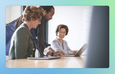 A group of people looking at a laptop.