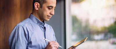 A person holding a pen and a tablet.