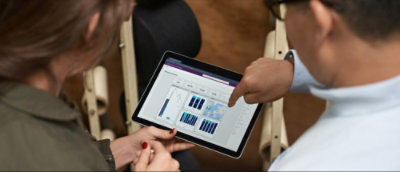 Deux personnes examinent des graphiques à barres sur l'écran d'une tablette.