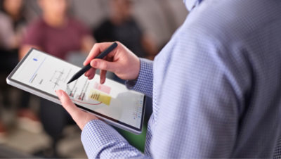 人物がタッチスクリーンのノート PC で作業しています