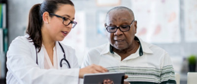 A person and another person looking at a tablet