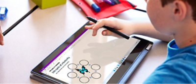 A hand holding a stylus on a tablet with text displayed on the screen.