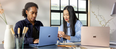 A man and woman looking at a laptop.
