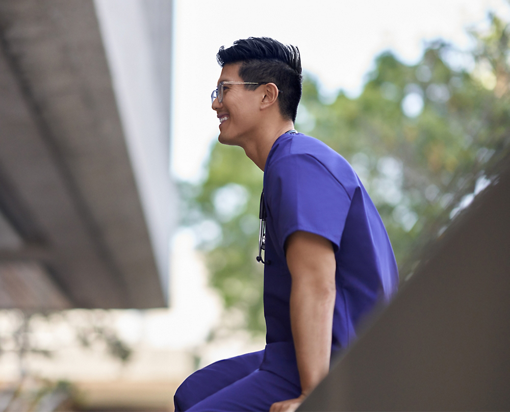 A person in blue scrubs smiling