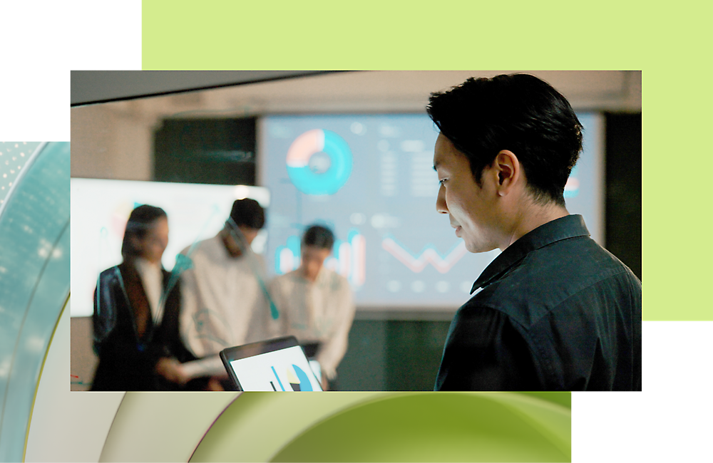 Biznismen koristi tablet sa kolegama i razgovara o podacima na digitalnom ekranu u pozadini.