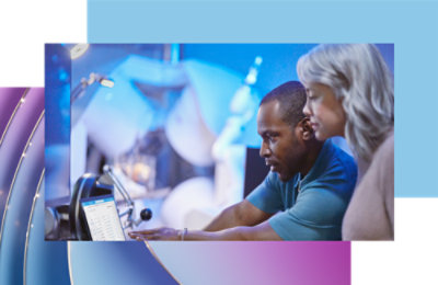 Dva profesionalca, muškarac i žena, zajedno rade na računaru u kancelarijskom okruženju visoke tehnologije.