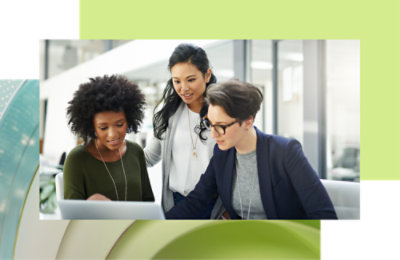 三位同事在现代办公室中使用笔记本电脑进行协作。